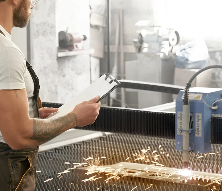 Engineer controlling plasma laser cutting metal